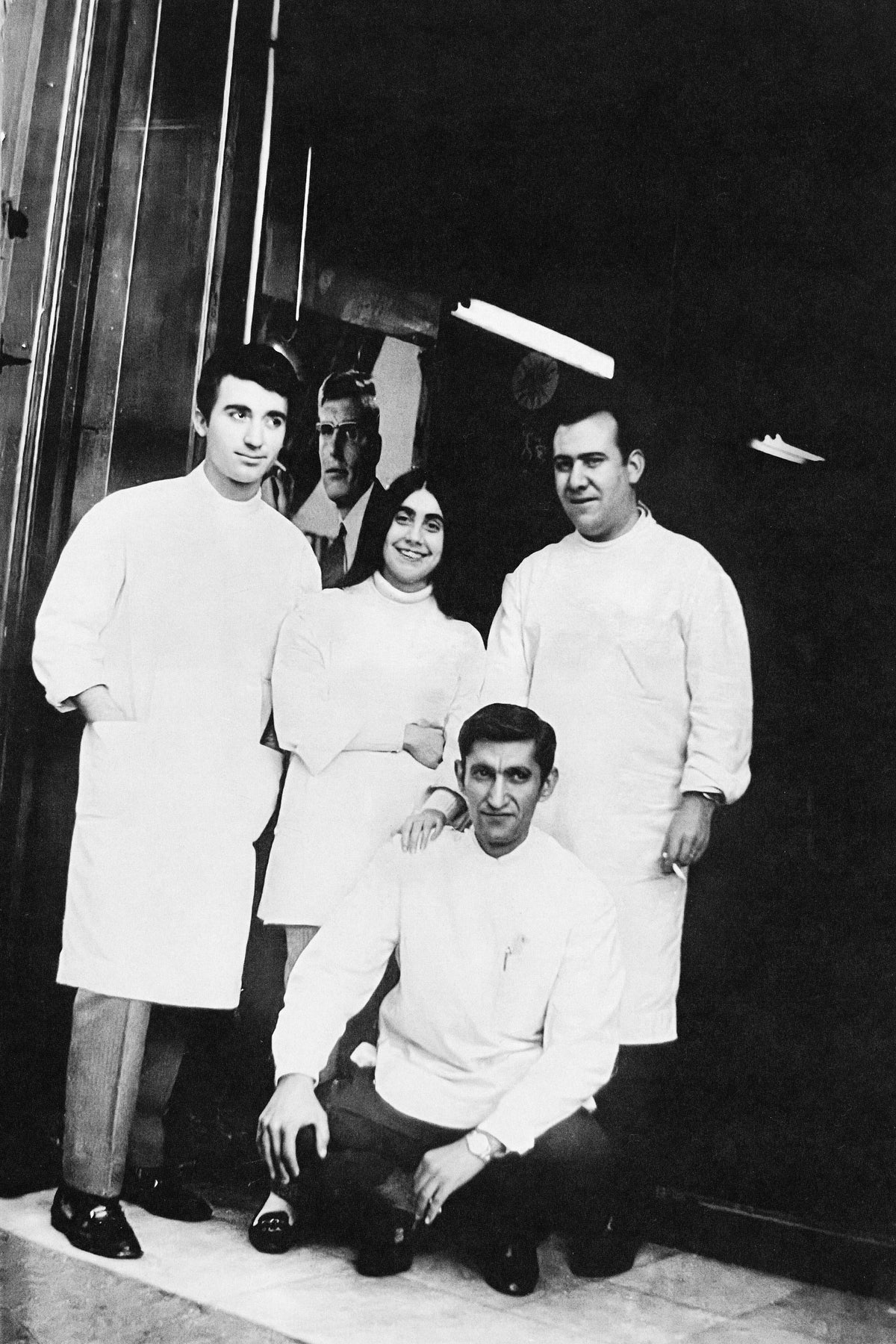 Equipo óptico fundador de Suitto con batas blancas, en una fotografía de archivo en blanco y negro