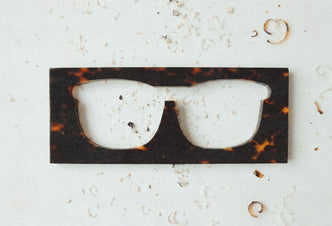 Plancha de acetato de carey con el frontal de unas gafas recortado durante el proceso de corte