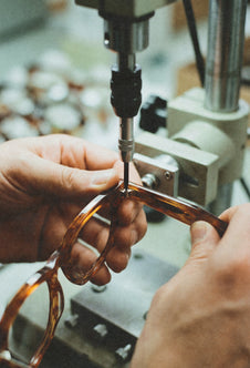 Manos de un artesano dando forma al frontal de unas gafas de sol Suitto